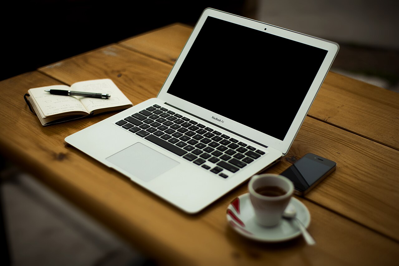 Home office scene with laptop and coffee, representing small business workspace